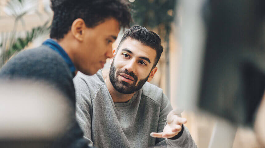 Programmers discussing over laptop